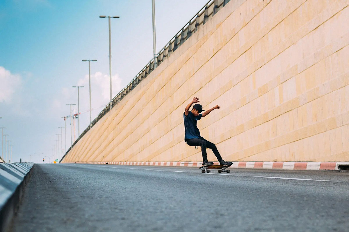 在马路上滑滑板的少年